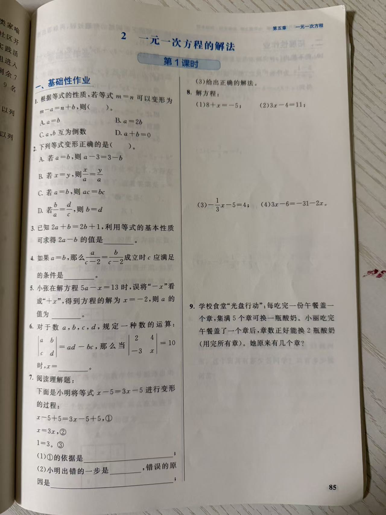 练习册第 85 页:第五章一元一次方程"2 一元一次方程的解法"第 1 课时"一、基础性作业"第 1–9 题,含等式变形条件选择、变形正误判断、等式两边同减求 2a−b、除数 c−2 非零条件、看错符号代回求 a、行列式新定义、小明除以 x 纠错阅读题、等式性质解四道方程与光盘行动集章换酸奶应用题。